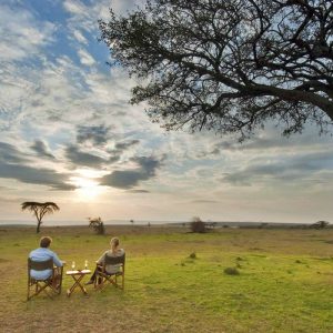 Tourists relaxing while looking into the sunset at Masai Mara National Reserve